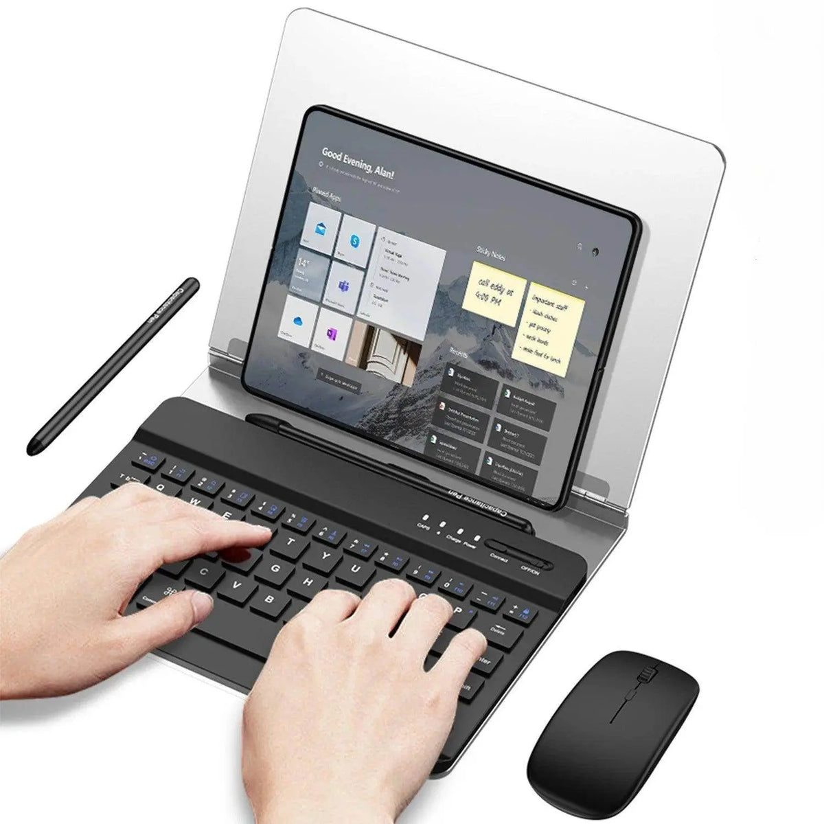 Hands typing on black keyboard with tablet holder showing a tablet screen and black wireless mouse